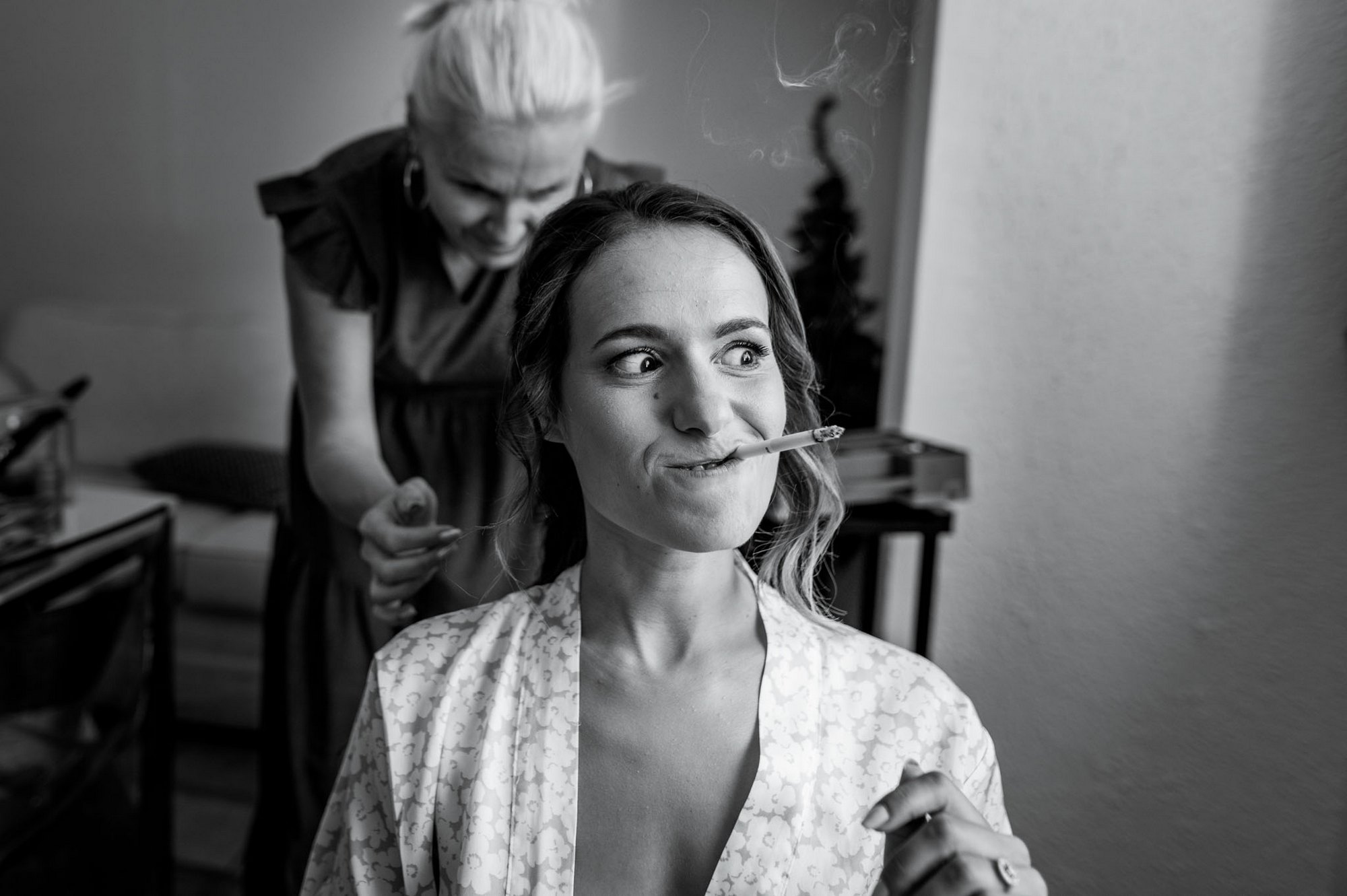 Photographe mariage Yvelines - Instant d'humour et décalé de la mariée avec une cigarette pendant ses préparatifs en noir et blanc.